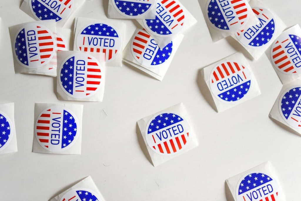 Scattered “I Voted” stickers on a white surface, representing questions about Christian political participation and voting.