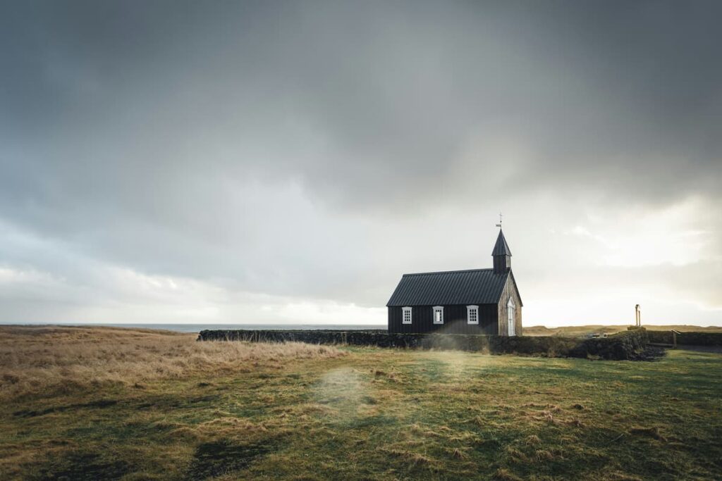 Small church building in an open field, representing belonging, commitment, and accountability within a local congregation.
